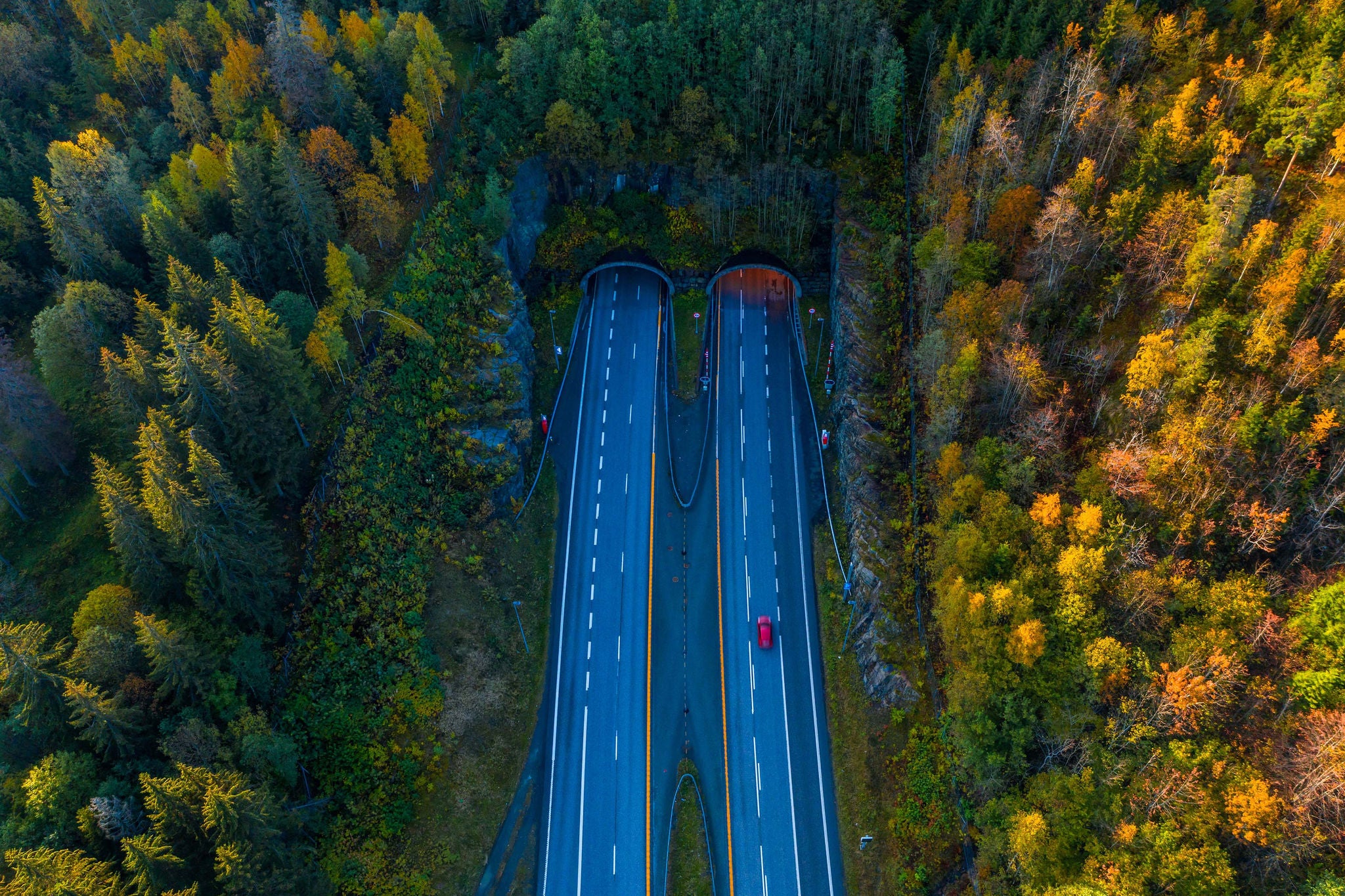 This is one of several tunnels on the highway which leads into Drammen city from south.  This aerial image was taken on a sunday morning in October 2019. The forest which are surrounding the highway have orange autumn colors. This area is called Sande.