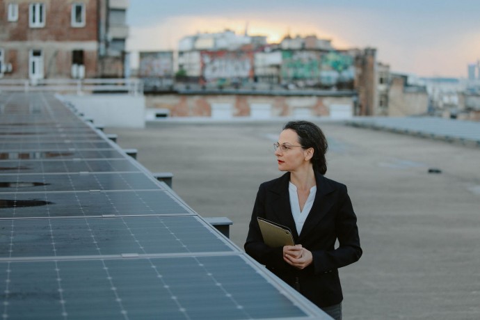 Businesswoman inspecting solar panels on the city rooftop