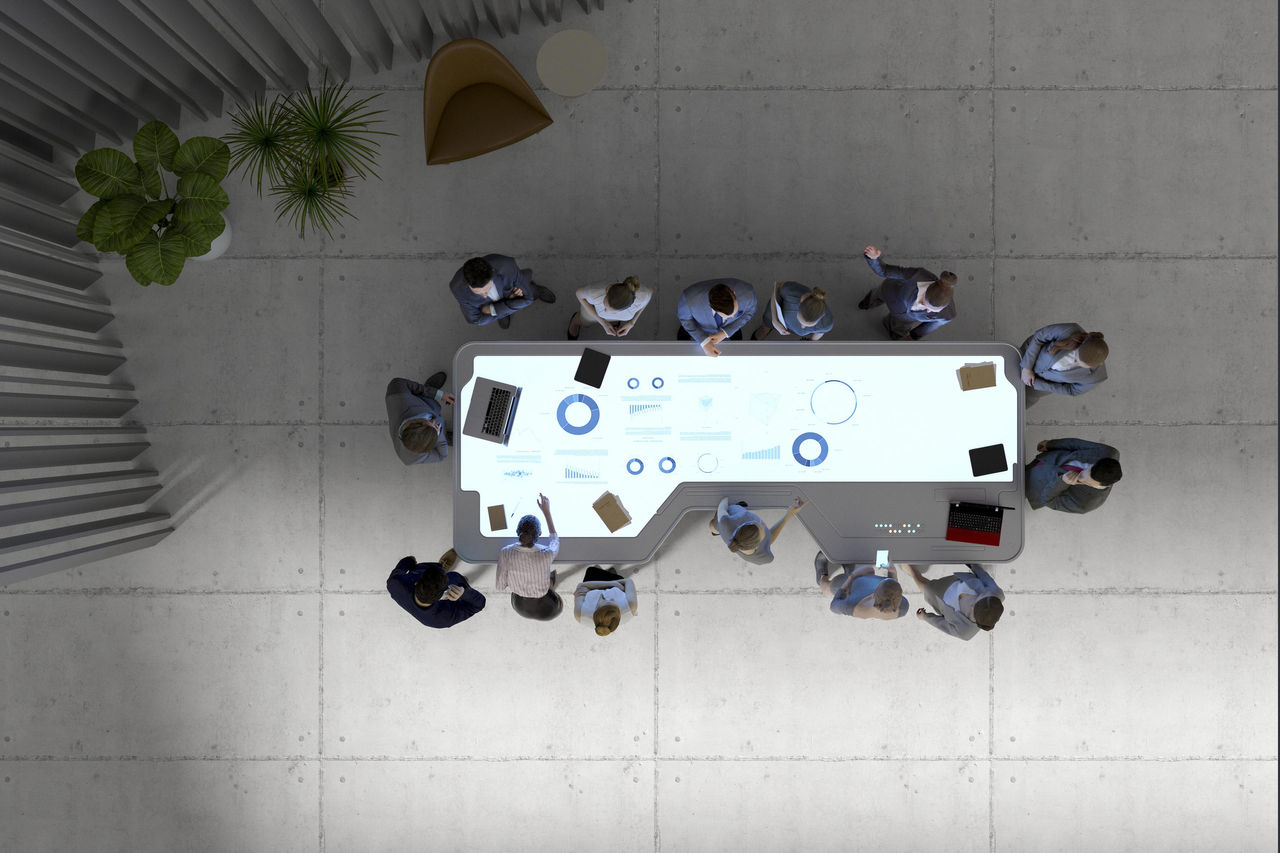 Group of business people with futuristic working desk. This is entirely 3D generated image. All graphs, charts and other elements on the desk display are my own images.